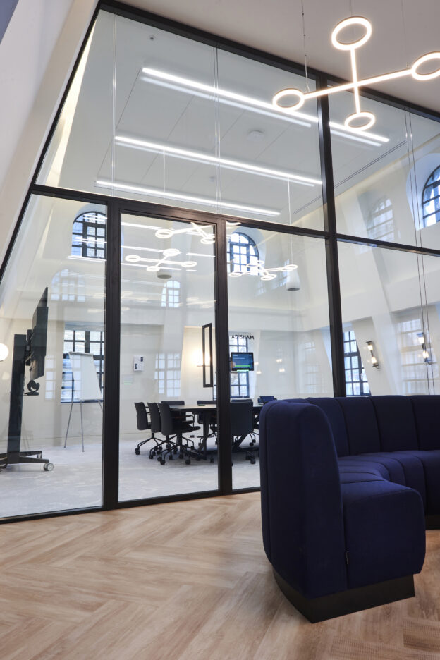 An open meeting space behind a panelled glass wall